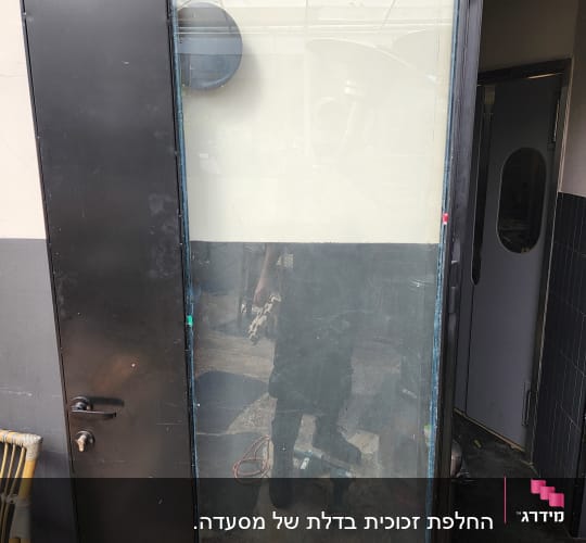 דלת זכוכית עם מסגרת מתכת ושיקוף חלקי
